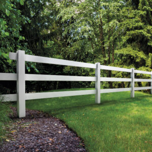 White wood fencing with green lawn and trees.