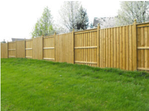 Picture of landscaping in front of a newly installed wood fence in the house. 
