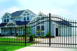 A picture of an aluminum fence in front of a blue house.