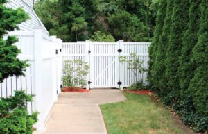 A beautiful tall, white fence in a residential backyard 